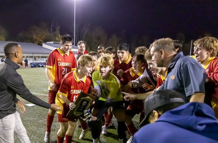 Calvert Hall's Rich Monath (left with trophy) prepares to do the celebratory hoisting of the MIAA A Conference trophy with his teammates after Sunday's title game. Monath's goal with 5 minutes, 27 seconds left in the second overtime lifted No. 1 Calvert Hall to a 2-1 victory over second-ranked John Carroll at UMBC.
