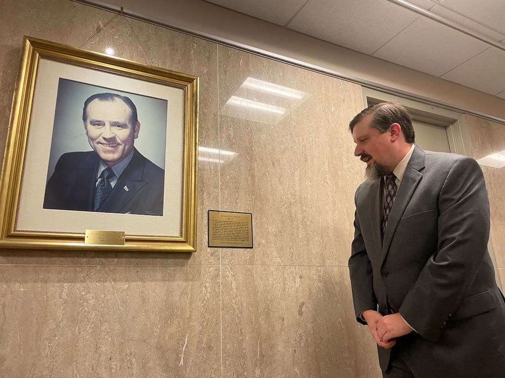 James Keffer, executive director of the Historical Society of Baltimore County, reads a new informative plaque about Dale Anderson, a former Baltimore County executive who served prison time on federal charges of extortion and tax evasion, on Monday, Oct. 16, 2023. . The portraits of Anderson and other past county executives line a hallway in the Historic Courthouse in Towson.