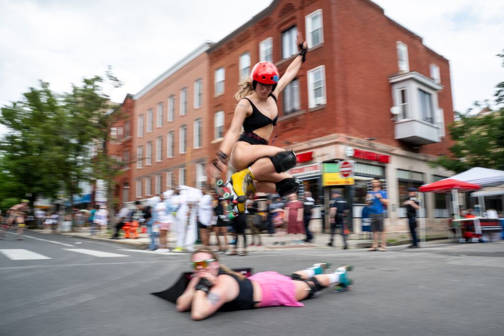 CIB Baltimore skater, Teele, jumps over fellow skater, Taylor, mid-parade during the Baltimore Trans Pride Grand March on 6/29/2024 in Baltimore, MD.