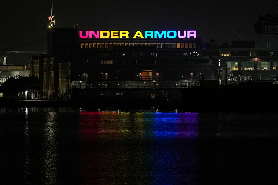 The Under Armour sign shines with rainbow colors over the Inner Harbor on June 29, 2023.
